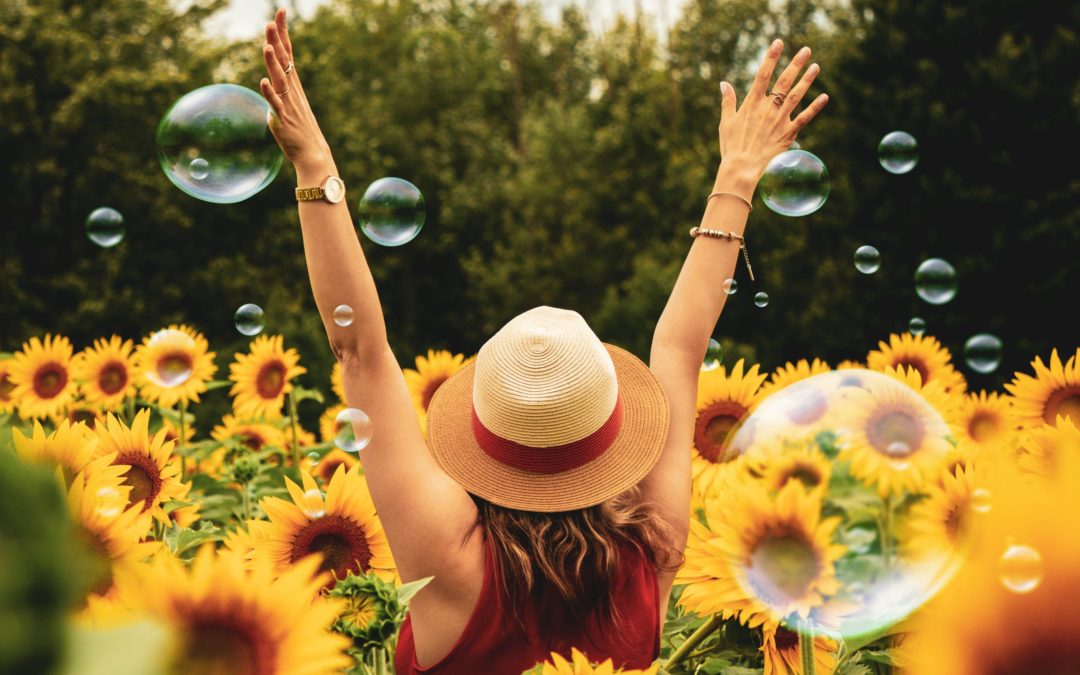 Girl walking in sunflowers with bubbles
