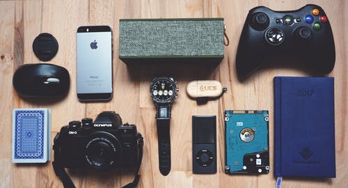 Make money selling your electronics. Picture of a watch, camera, iPhone, game controller in flat lay photo