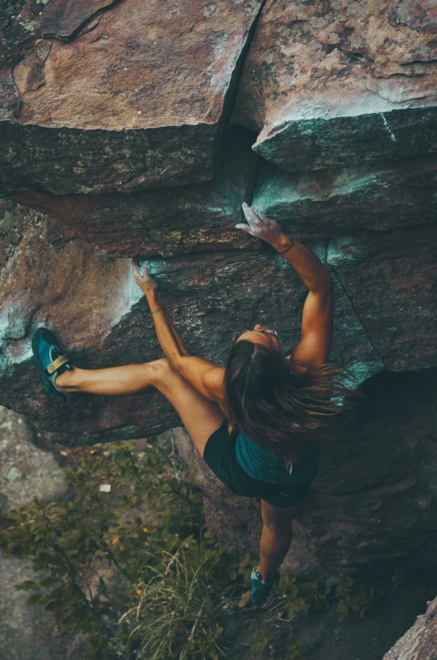 Get-Back-On-Track-With-Your-Goals Woman rock climber climbing mountain with no safety ropes