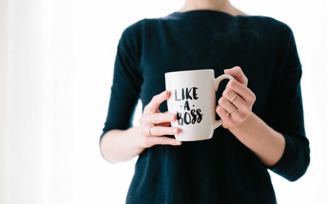 Get-Back-On-Track-With-Your-Goals-Wealthese.com Woman holding coffee cup that reads "Like A Boss."