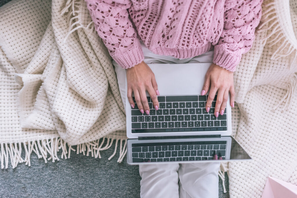 How to Become a Freelance Writer Woman Sitting in Pink Sweater at computer