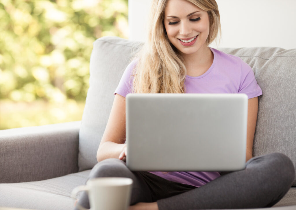Stay at Home Jobs woman sitting on couch working on computer at home