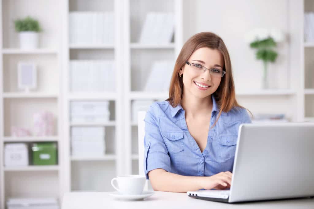 Stay at Home Jobs woman smiling while working on computer at home